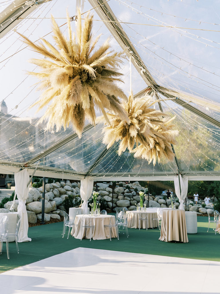 Clear event tent and pampas hanging installation for a Summer backyard wedding reception in Alpine, Utah | Photographed by Utah Wedding Photographer Alora Lani, a fine art photographer based out of Southern California and Utah